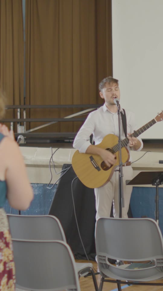 A worship leader with an acoustic guitar