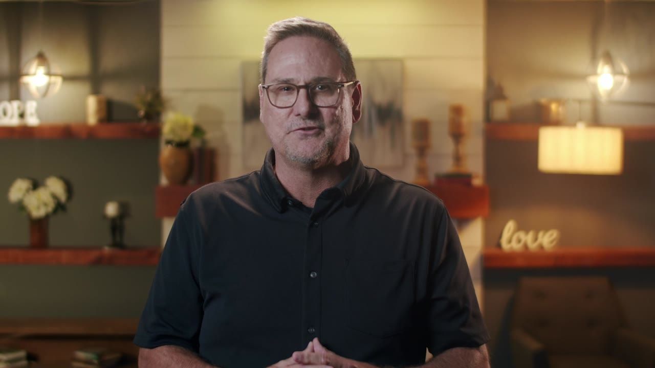 A pastor speaking to camera in a warm room