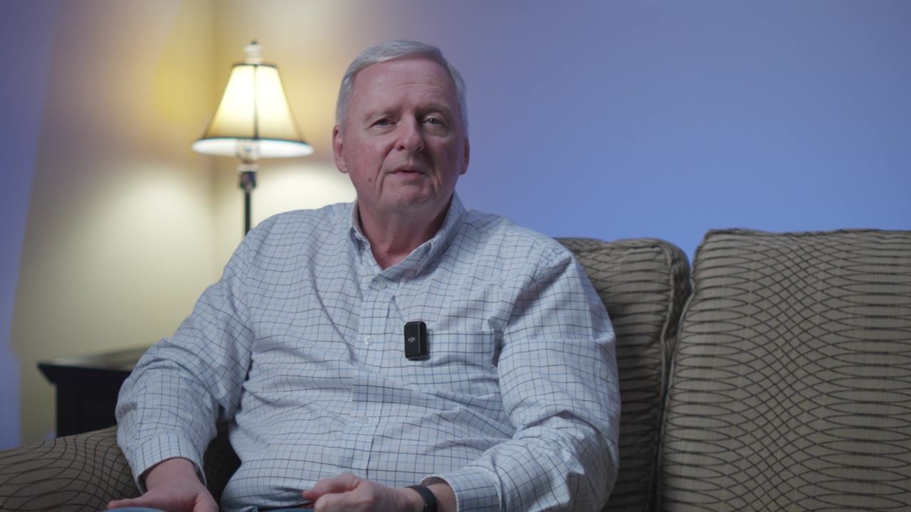 A man in a blue shirt on a couch