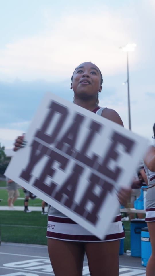A cheerleader holding a sign