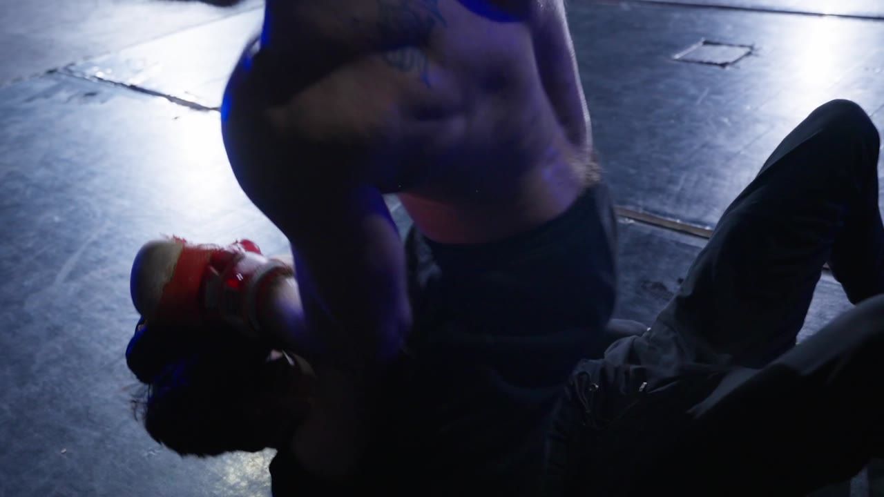 A fighter on the mat under blue light