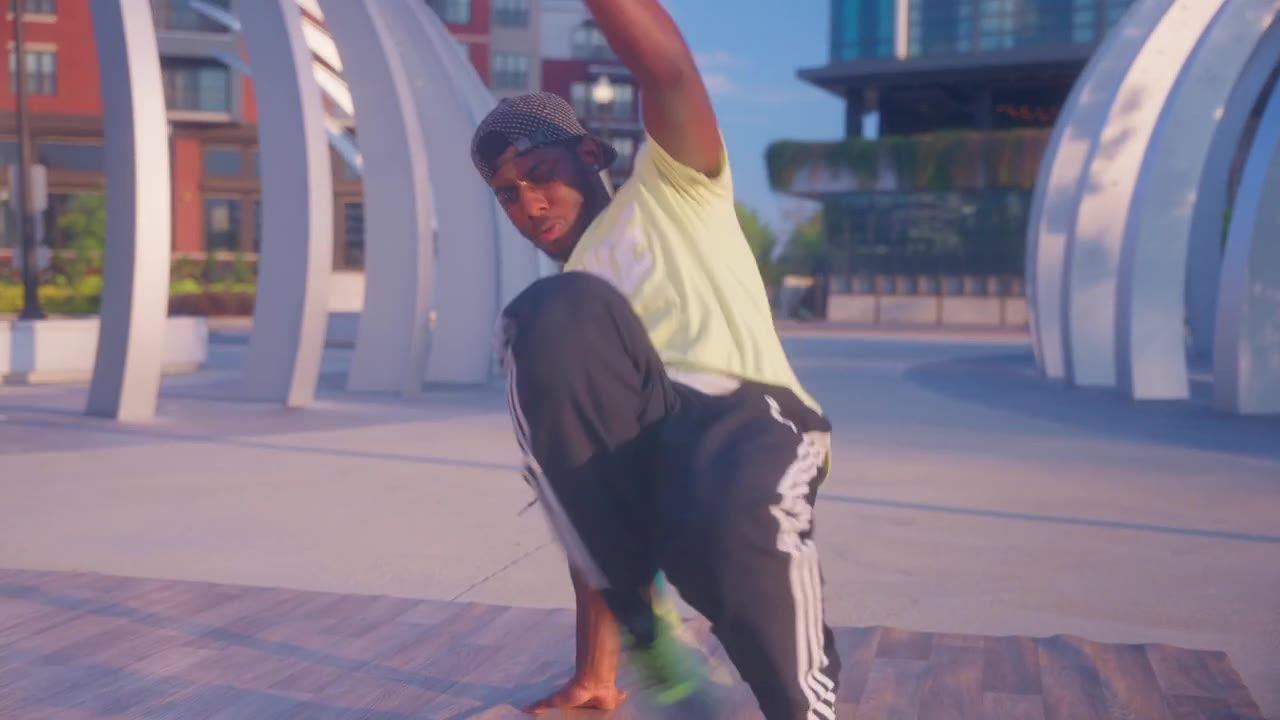 A dancer mid-move on a downtown plaza