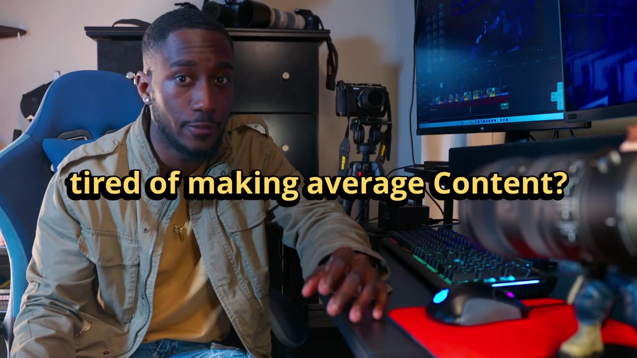 Cashawn seated at his edit desk with a cinema lens in the foreground