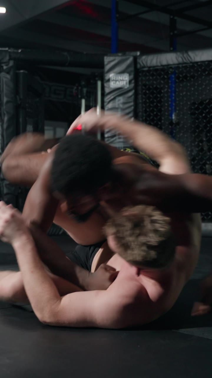Two fighters grappling on the mat