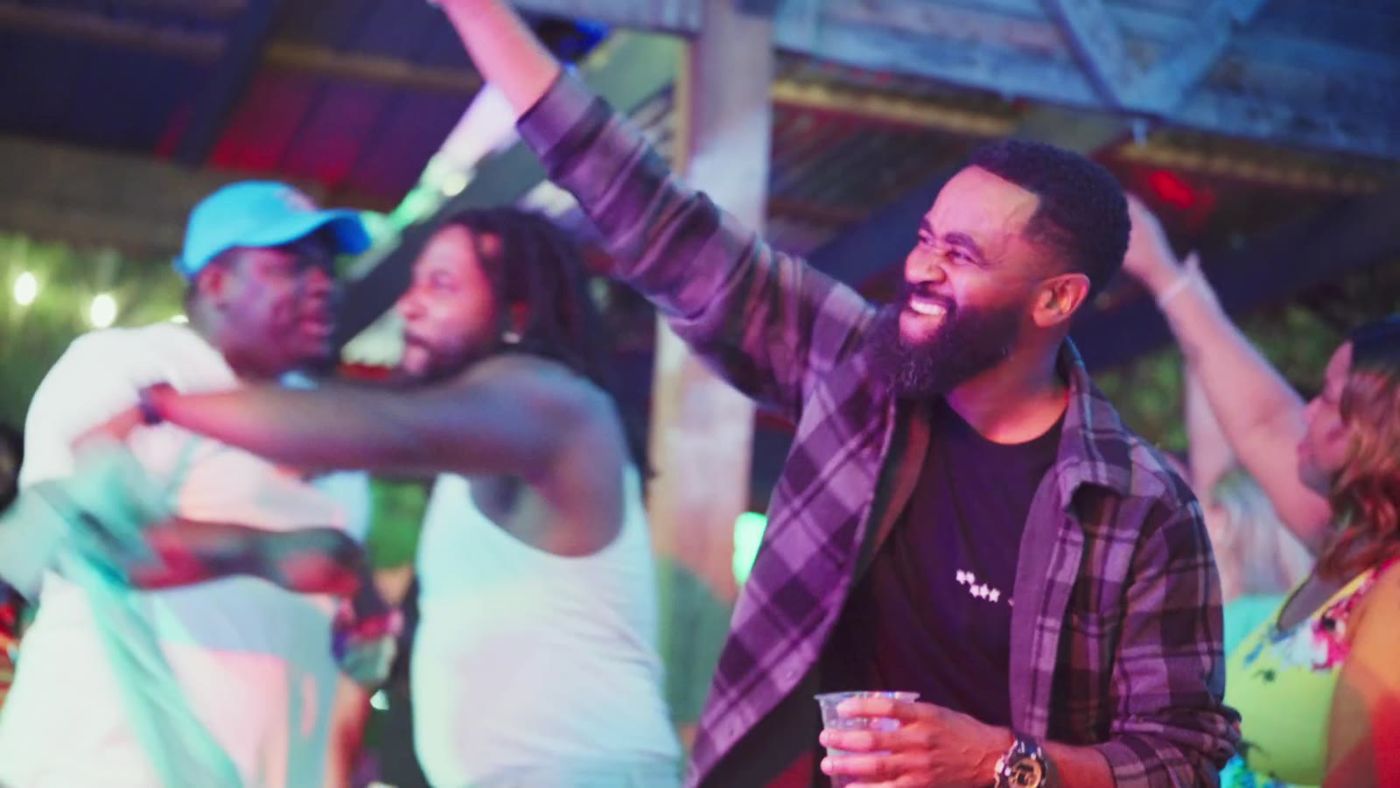 A crowd dancing and celebrating under colored party lights