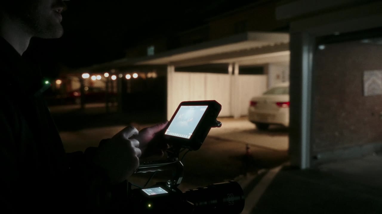 A camera monitor glowing on a night set