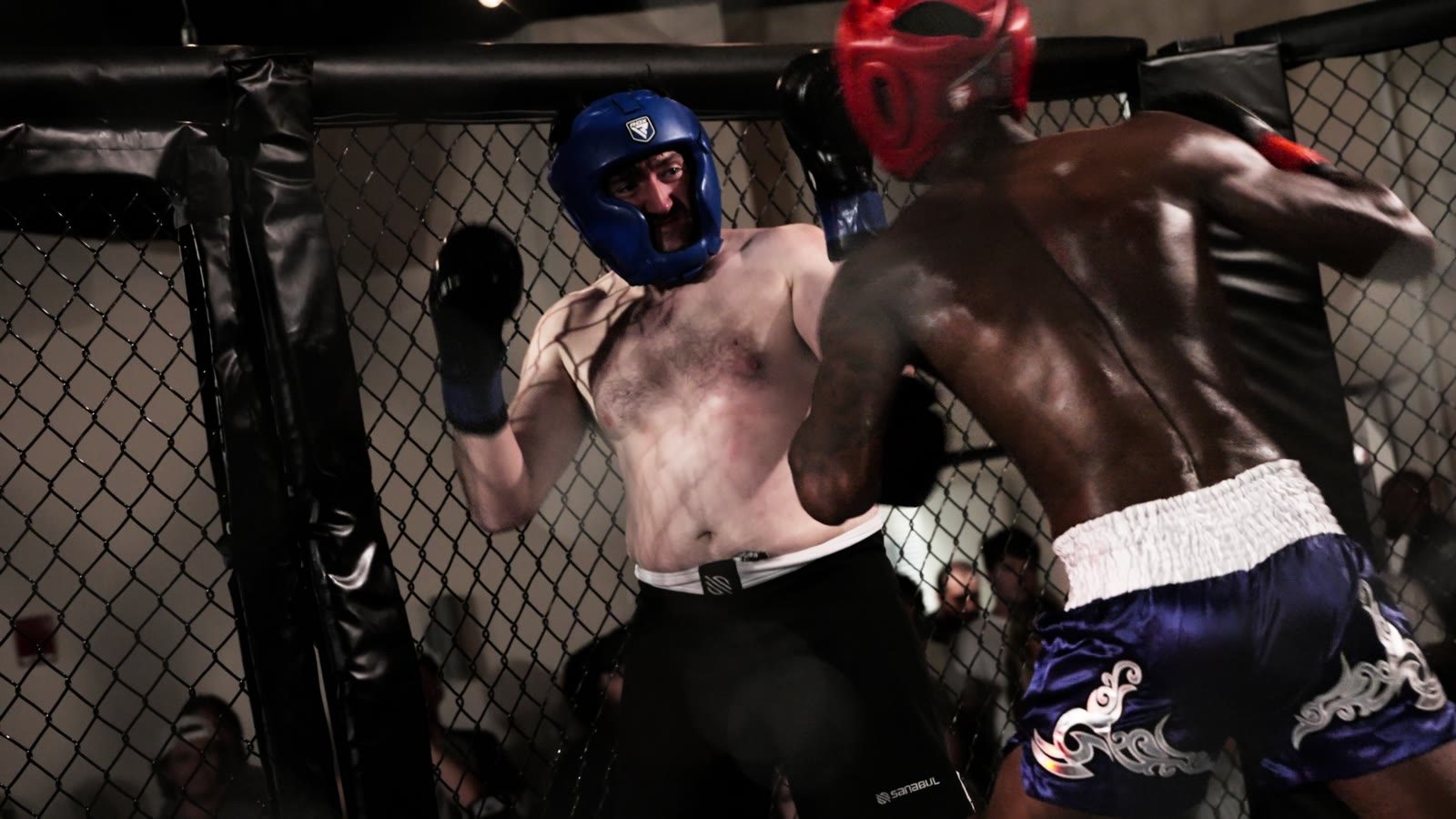 Two fighters exchanging punches inside a cage