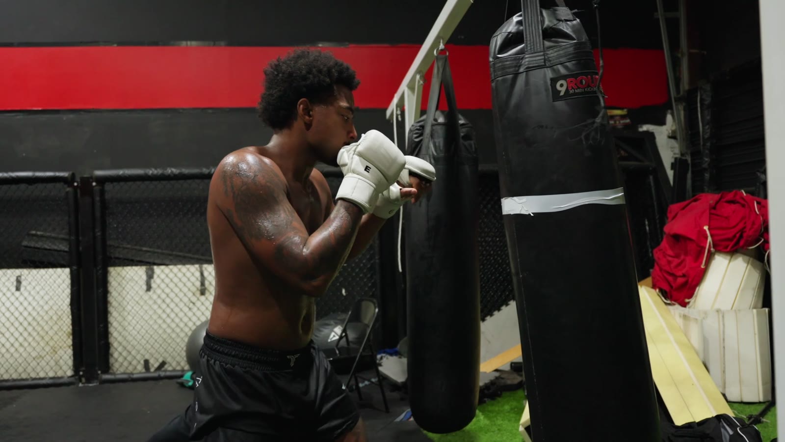 A fighter wrapping his hands beside a heavy bag