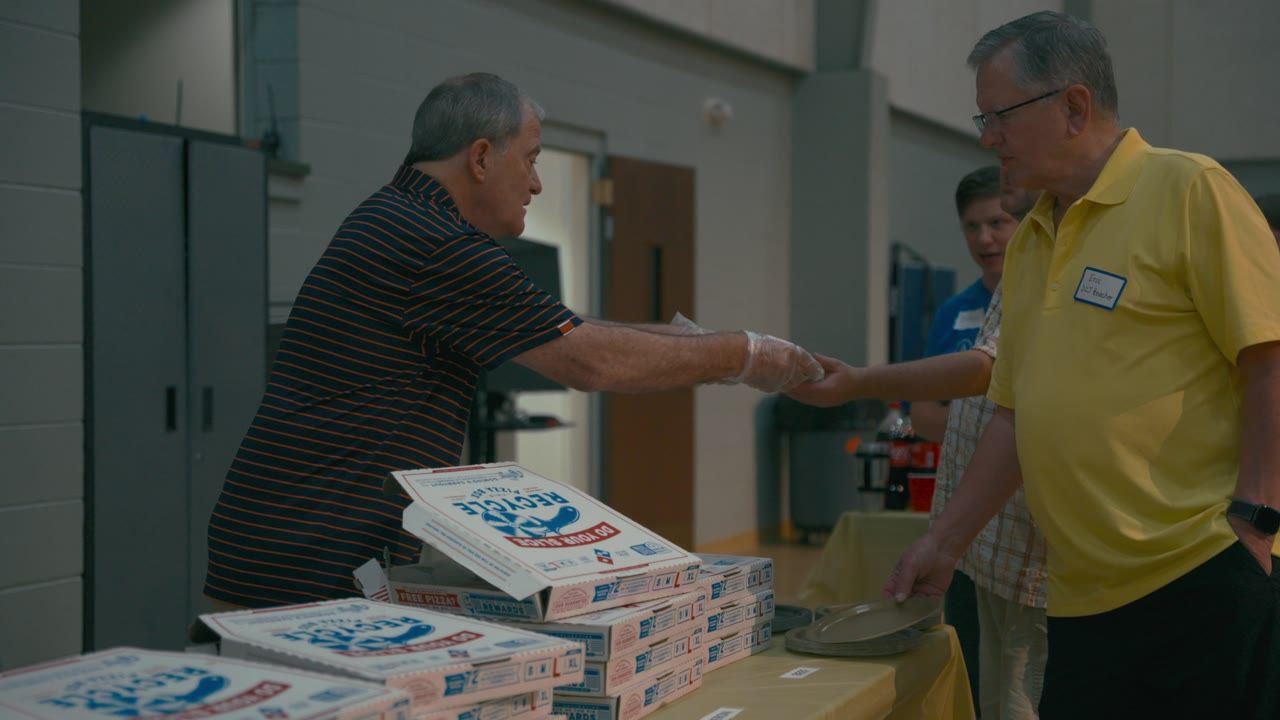 Volunteers handing out pizza