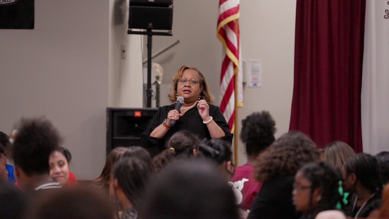 A speaker addressing students at an assembly