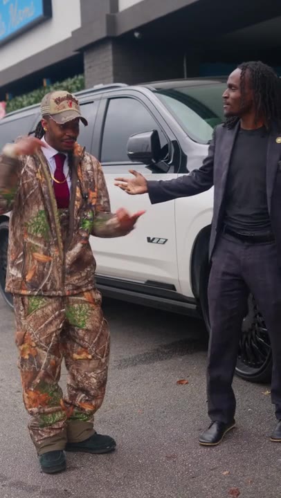 Plastoline owner in camo beside a client in a suit next to a wrapped white SUV